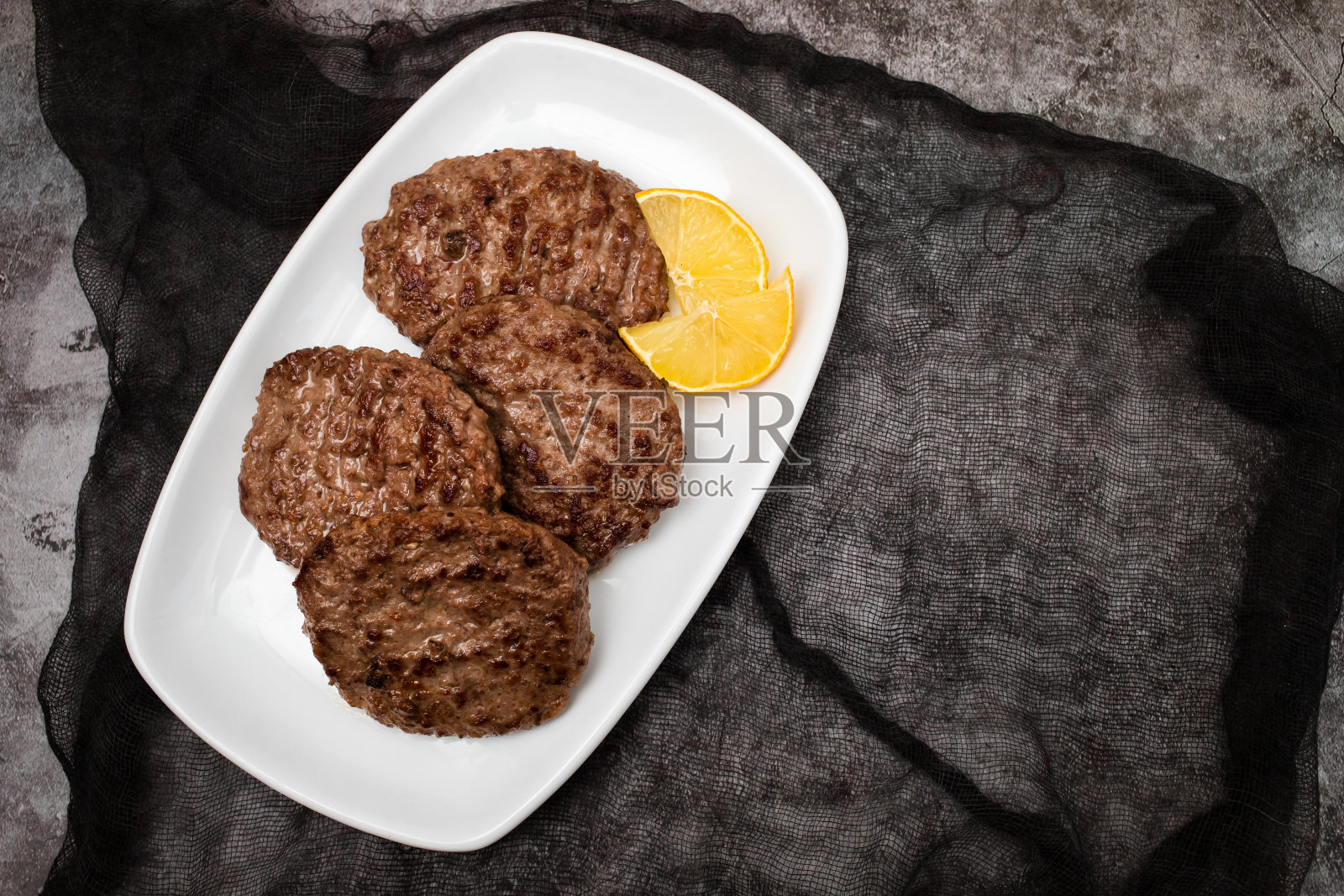 煎肉排配柠檬汉堡。装在白色盘子里照片摄影图片