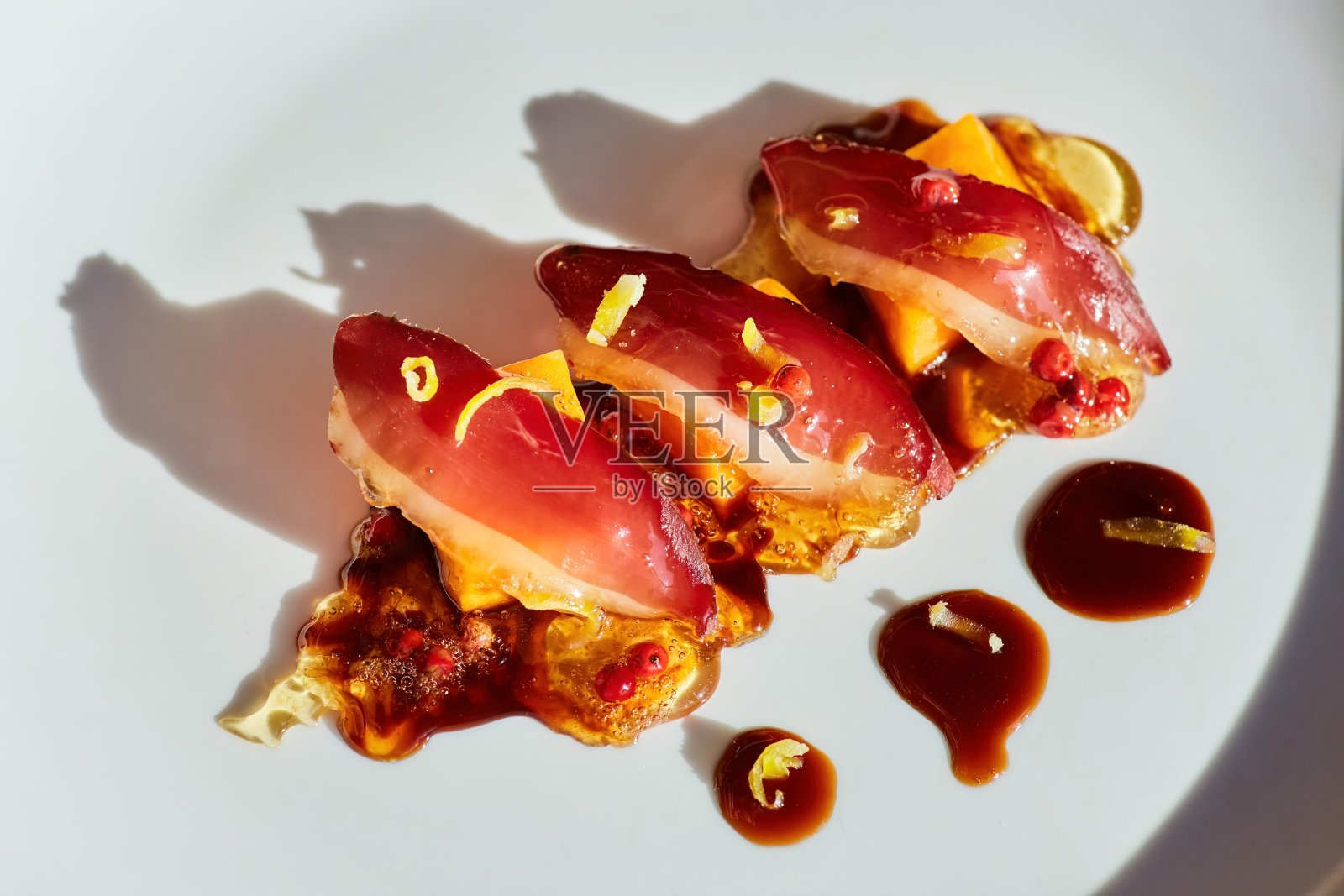 烤肉片放在三片烤南瓜上，撒上帕尔马干酪。里面有焦糖和蔓越莓。食物的风格照片摄影图片