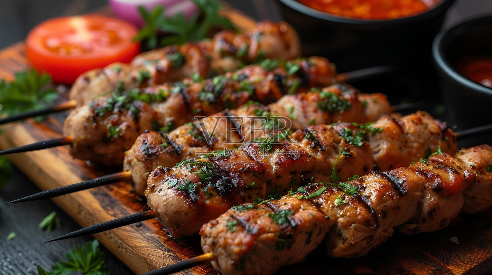 木制砧板，顶部放着鸡肉和各种蘸酱照片摄影图片