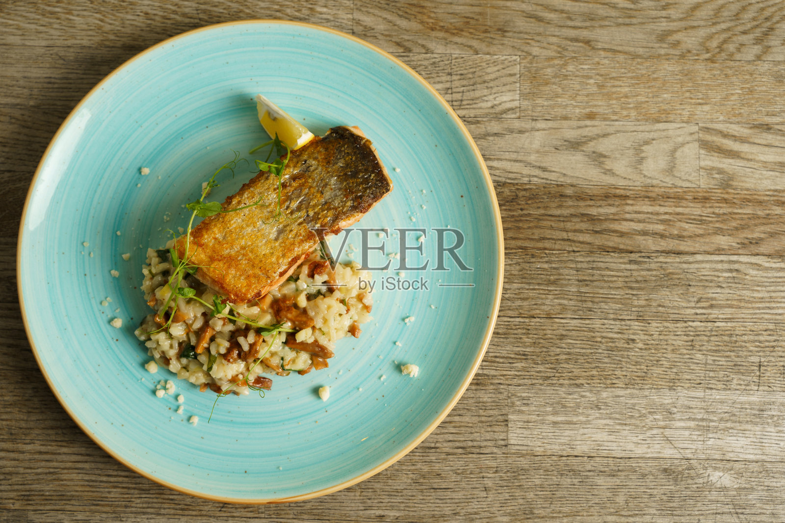 烤三文鱼配意大利烩饭和鸡油菌菇照片摄影图片