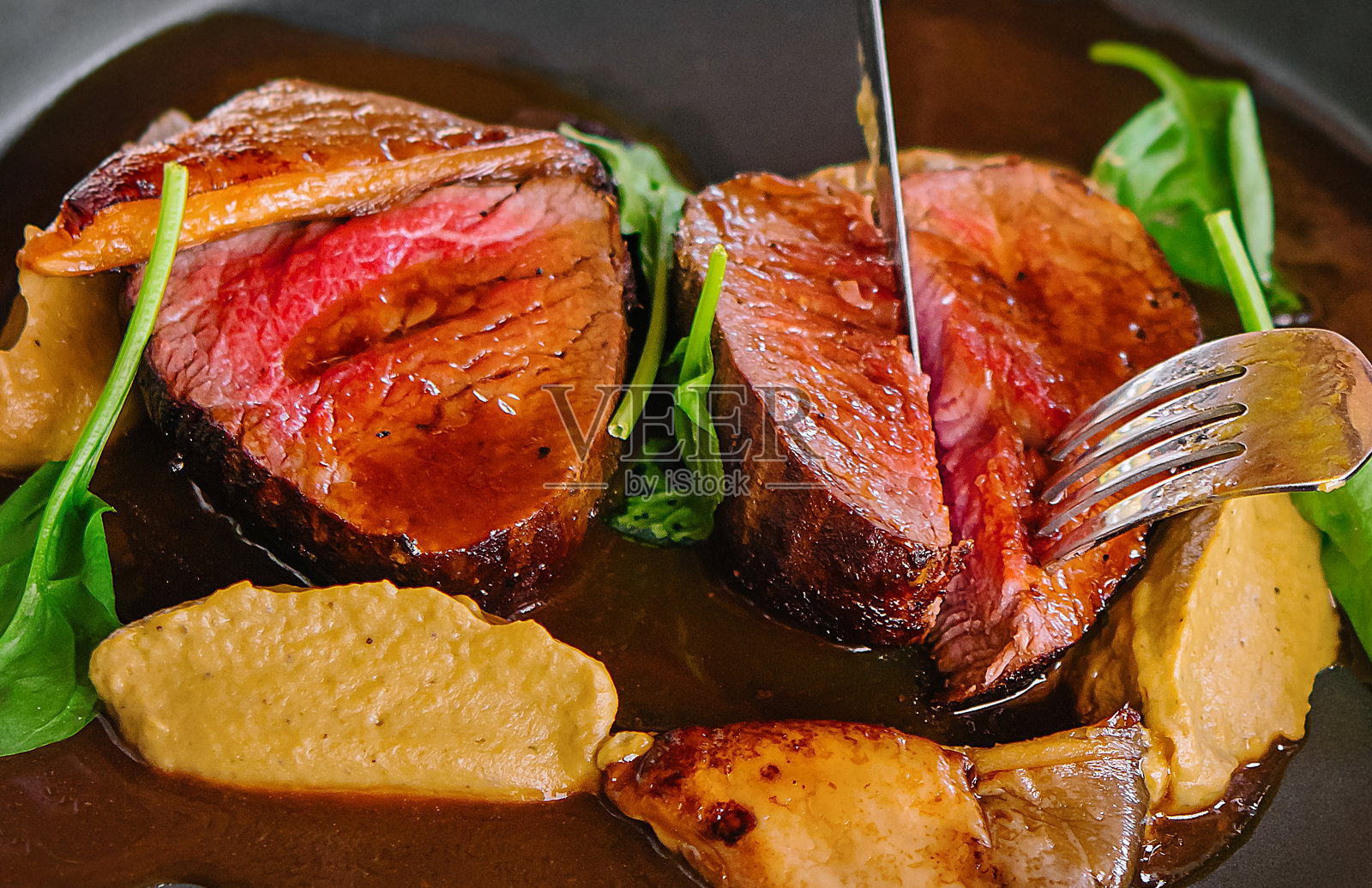 手里拿着刀叉，切着烤鸭照片摄影图片