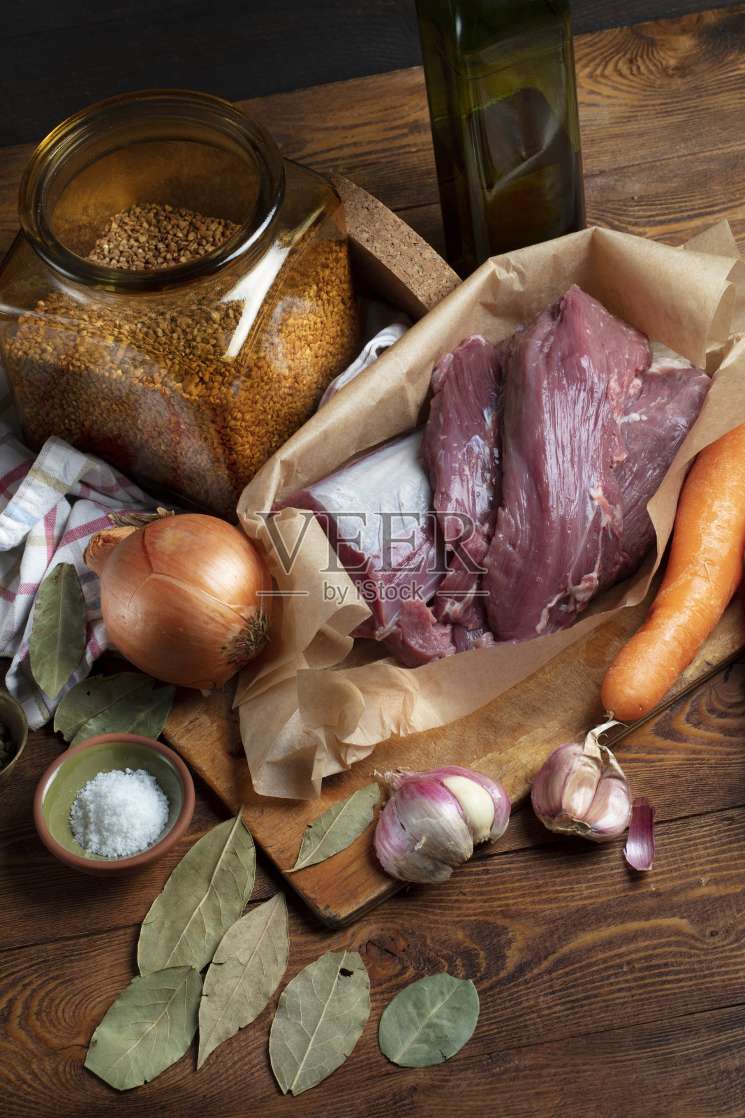 家庭厨房的基本食材:牛肉、胡萝卜、洋葱、大蒜、盐、胡椒、荞麦、橄榄油、月桂叶。健康乡村美食，慢煮理念照片摄影图片
