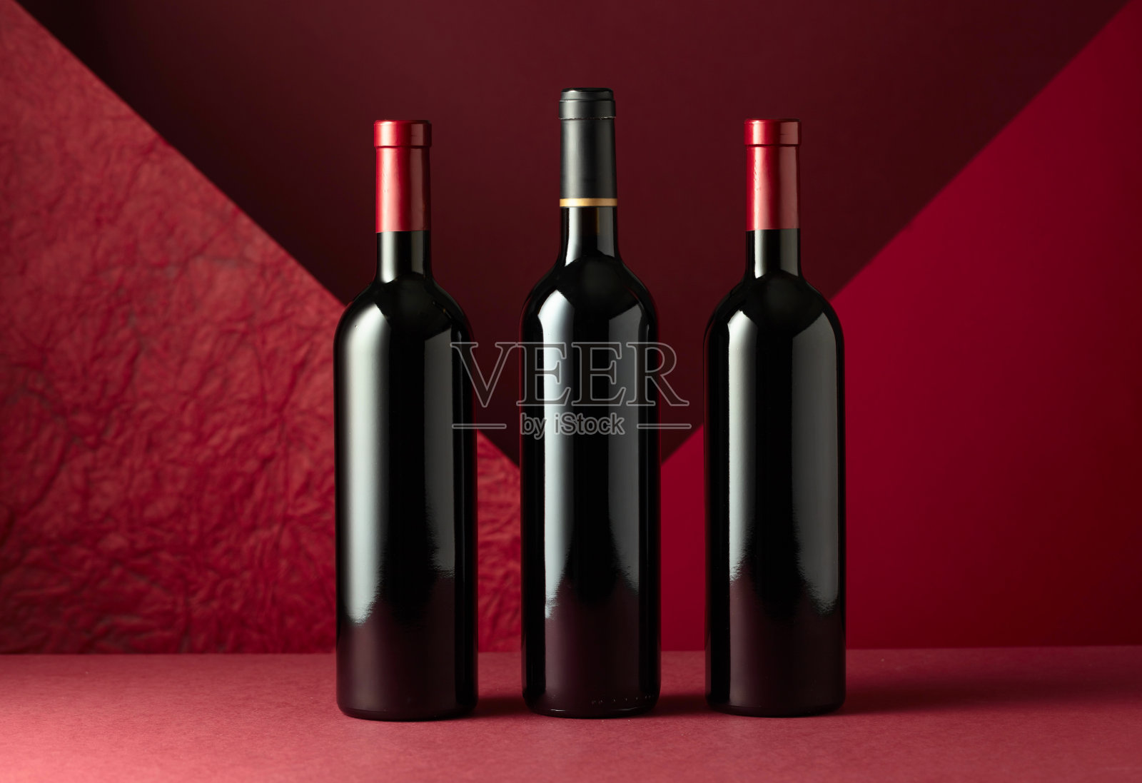 红色背景上的红酒。照片摄影图片