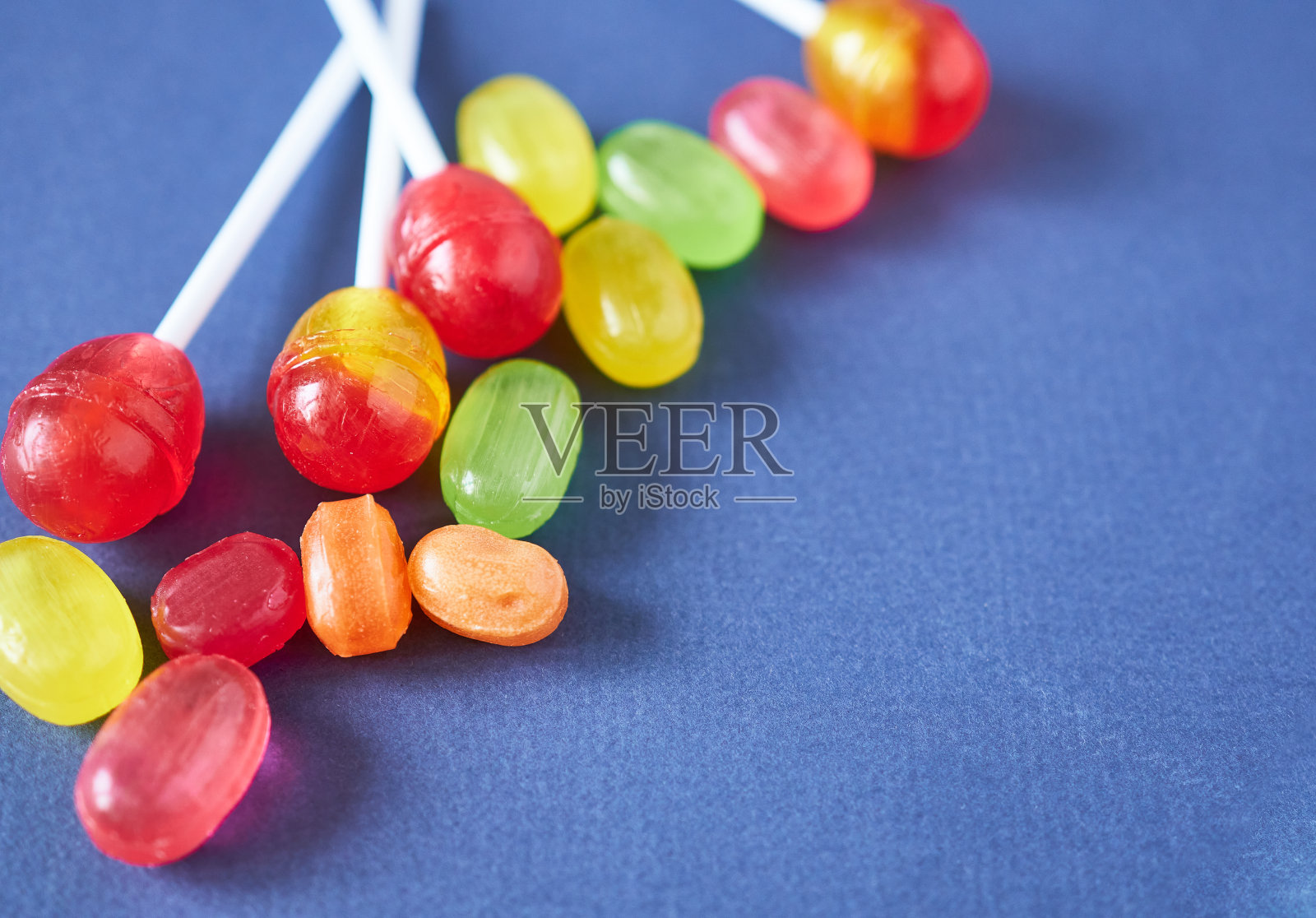 蓝色背景上的棒棒糖焦糖。照片摄影图片