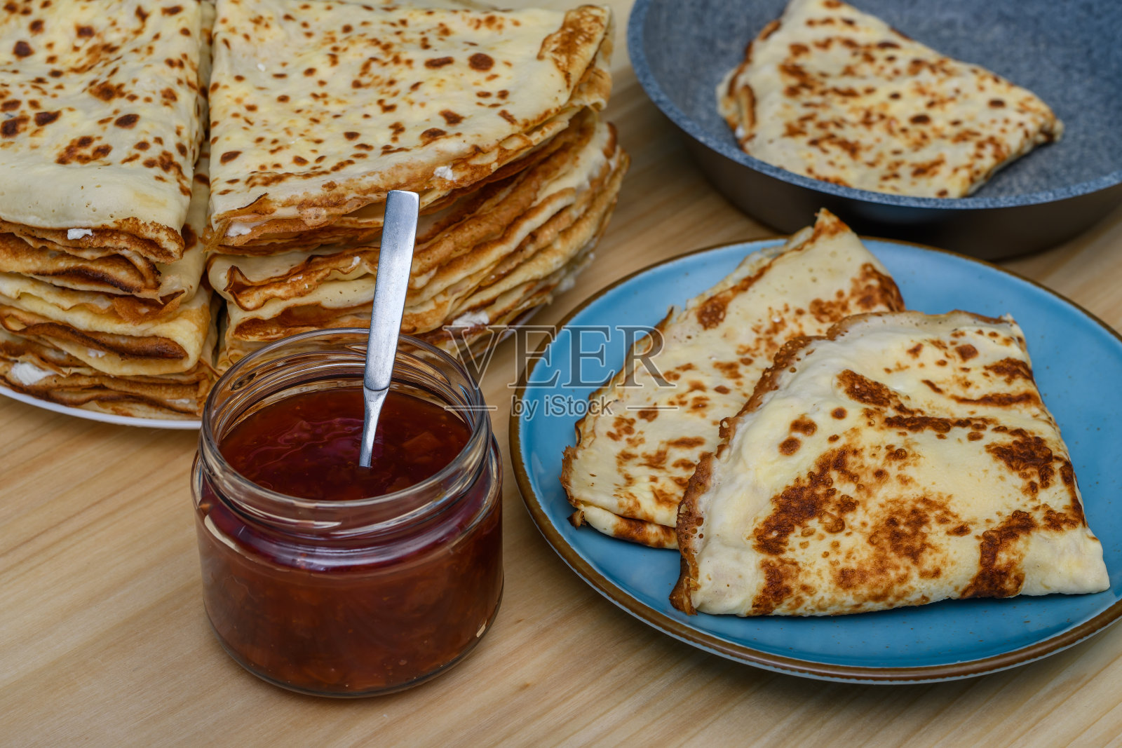 夹着果酱的法式可丽饼，卷成三角形的面团，里面塞满了白干酪照片摄影图片