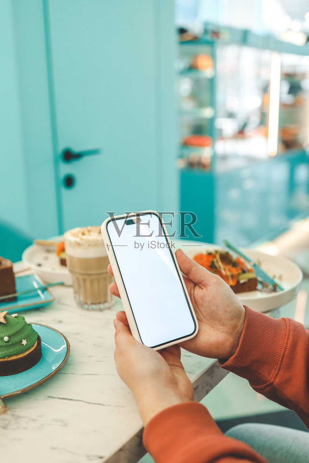 在餐厅的食物背景上有隔离屏幕的手机照片摄影图片