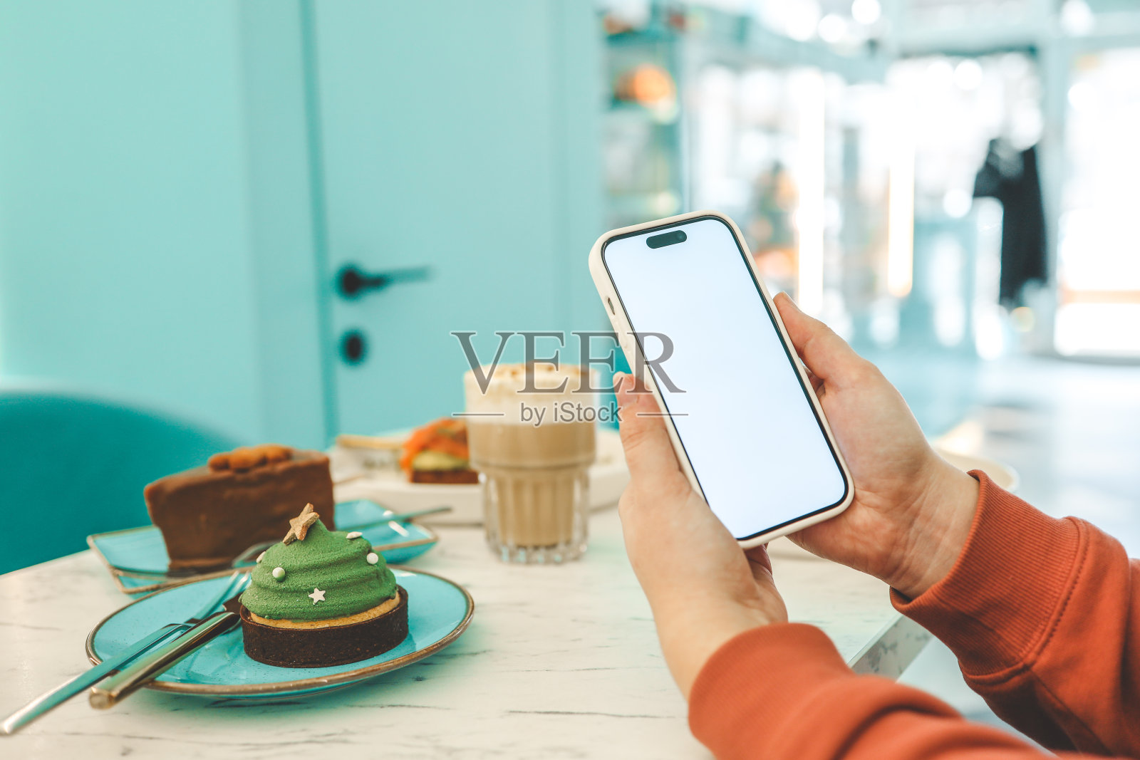 在餐厅的食物背景上有隔离屏幕的手机照片摄影图片