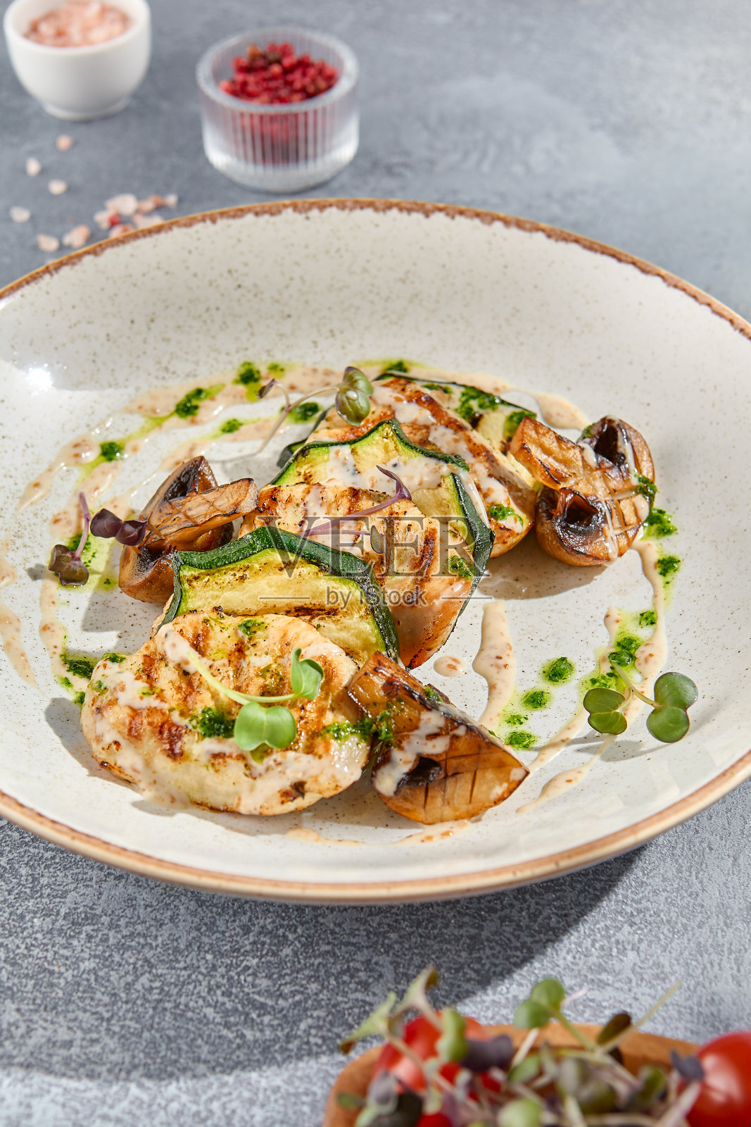 烤火鸡肉排配西葫芦和蘑菇的特写侧视图。优雅地展示在白色陶瓷盘子上，为健身菜单创造了简约而丰富的视觉效果照片摄影图片