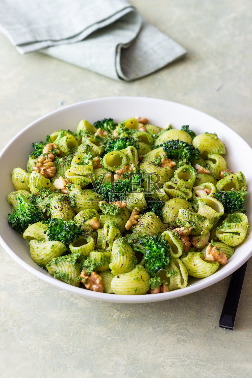 意大利面配西兰花，香蒜酱和坚果。意大利菜。健康饮食。照片摄影图片