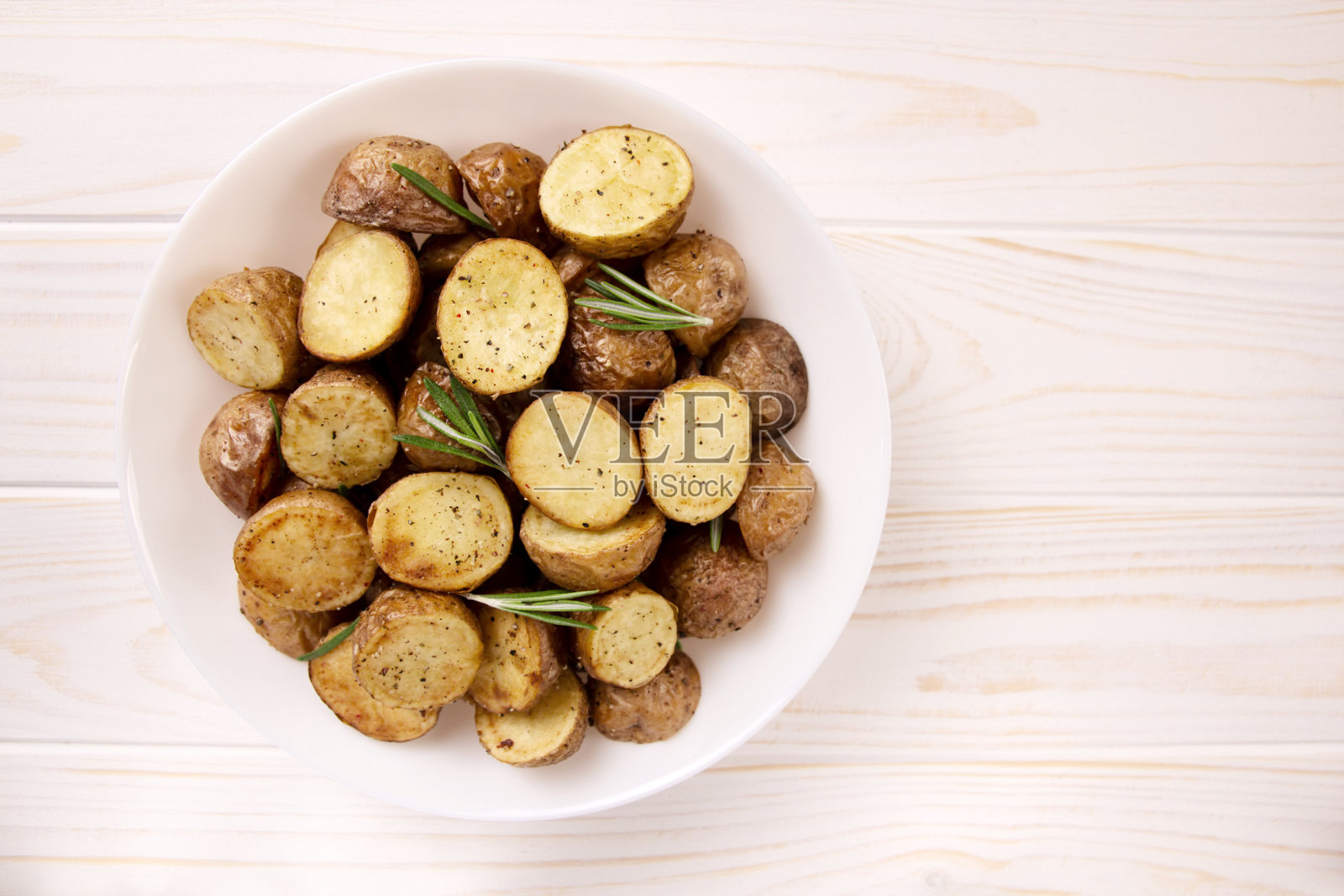 美味的烤土豆与迷迭香在浅背景照片摄影图片