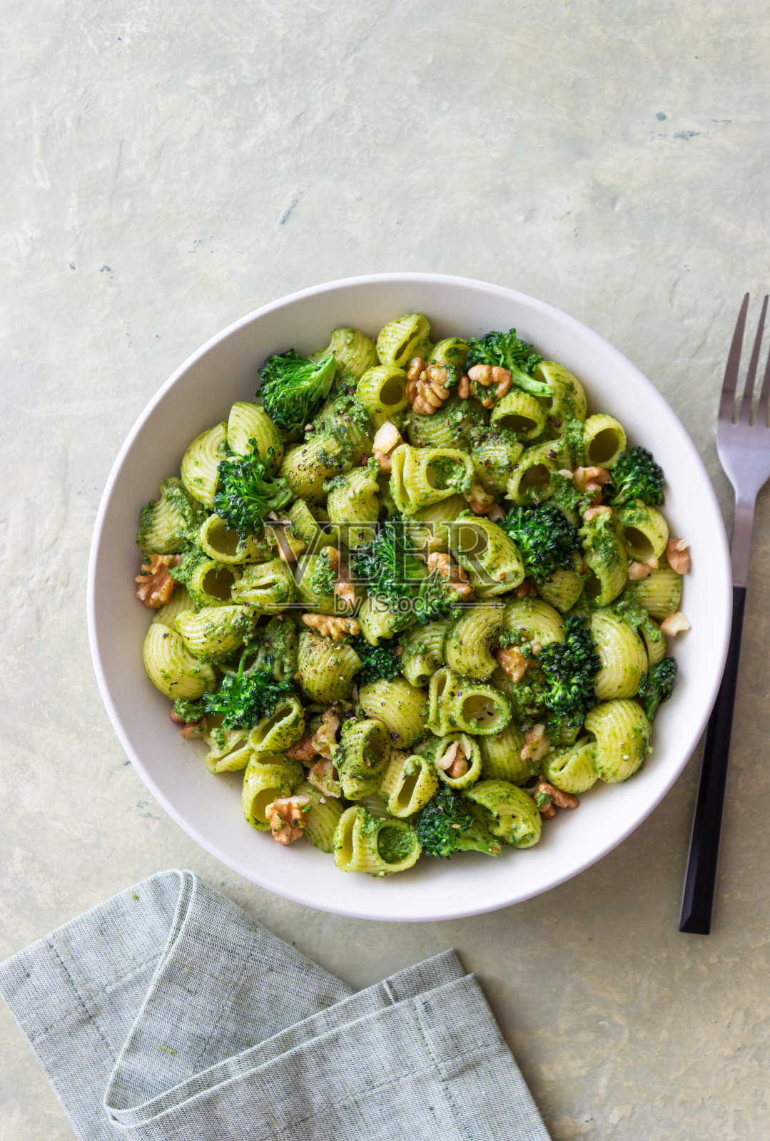 意大利面配西兰花，香蒜酱和坚果。意大利菜。健康饮食。照片摄影图片