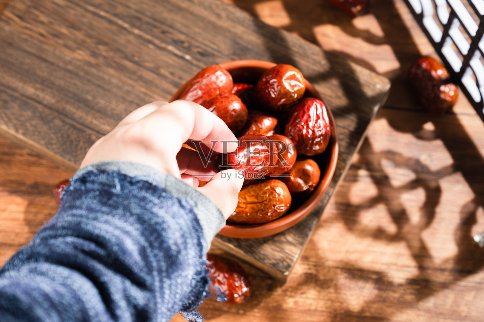木桌上篮子里的枣子照片摄影图片