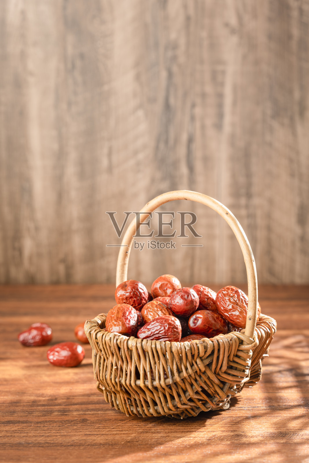 木桌上篮子里的枣子照片摄影图片
