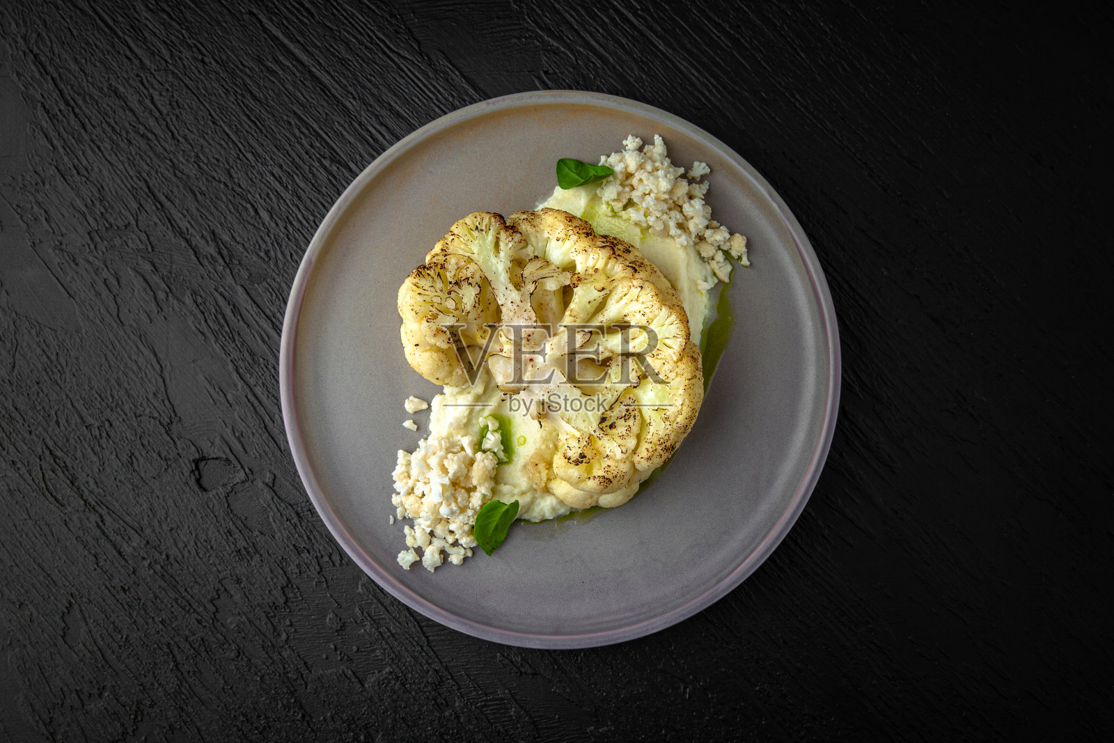 不丰盛的菜单。花椰菜牛排在绿色酱在一个陶瓷盘子在黑暗纹理的背景。餐厅的菜单照片摄影图片