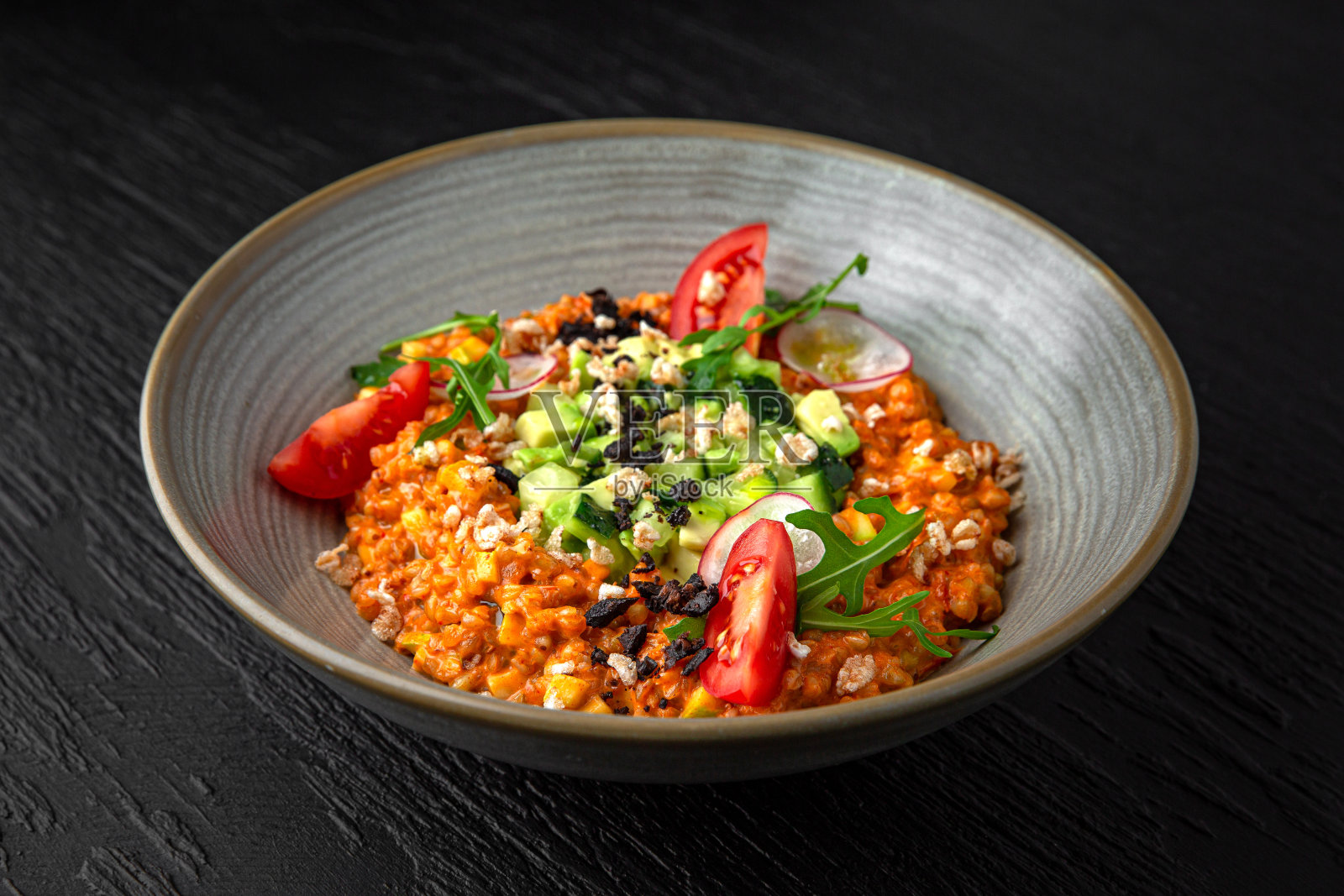 不丰盛的菜单。在深色纹理背景的陶瓷盘子里放上鳄梨鞑靼格列乔托。餐厅的菜单照片摄影图片