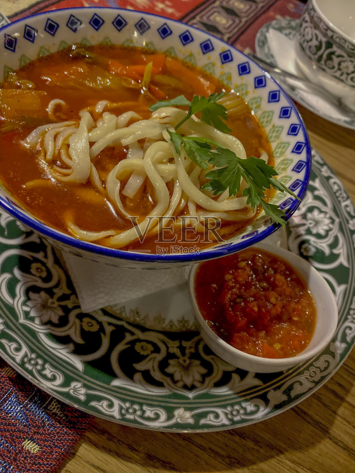 红鱼子酱汤和木桌上的面条。照片摄影图片