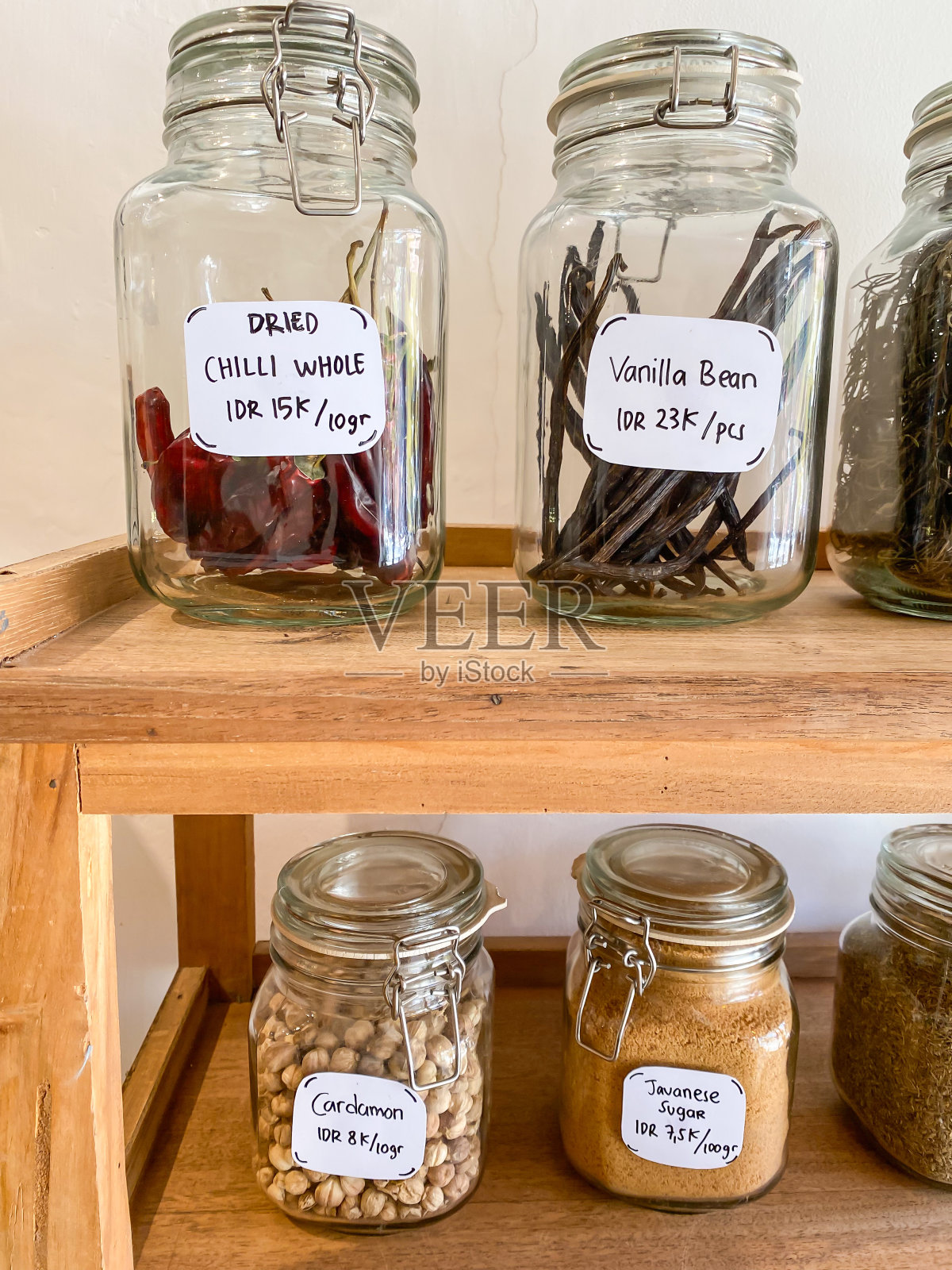 干辣椒、香草豆、小豆蔻、爪哇糖装在透明的玻璃罐中出售。日用品店，出售各种调味品、配料、调味料、干香草和香料。照片摄影图片