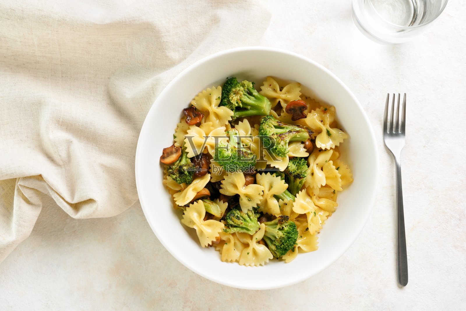 碗里有烤西兰花和蘑菇的意大利面照片摄影图片