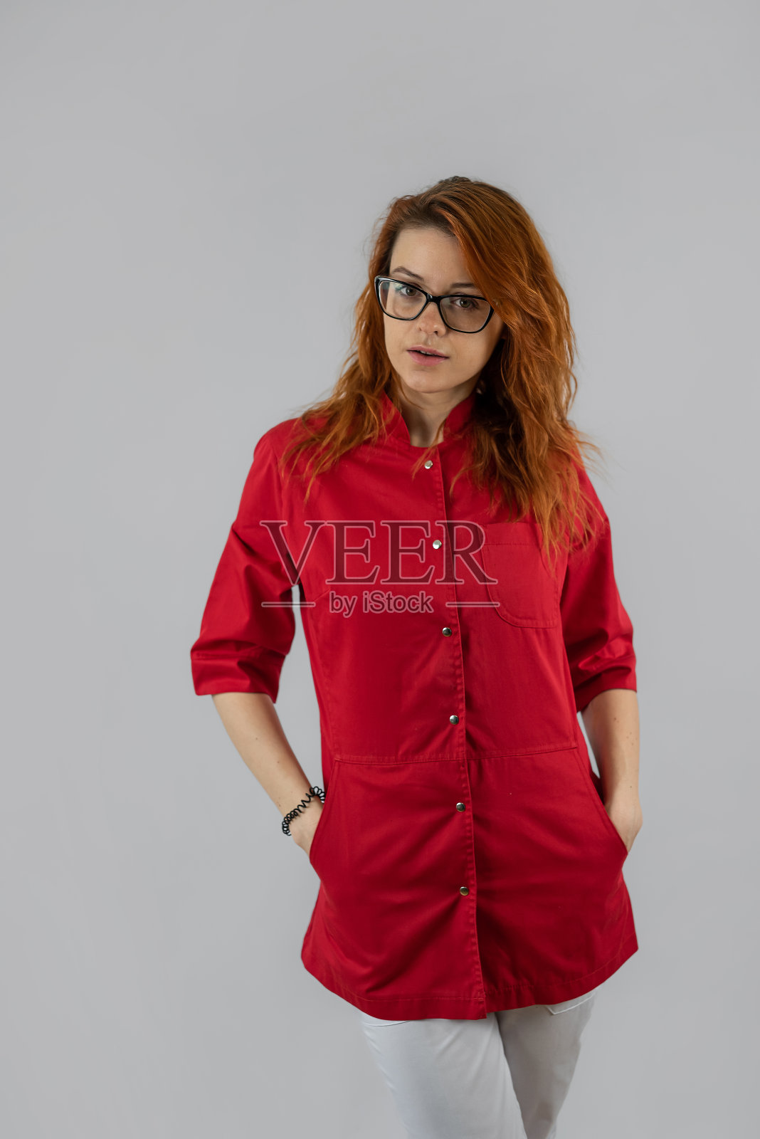 年轻漂亮快乐的女护士的肖像，穿着红色的制服，与世隔绝照片摄影图片