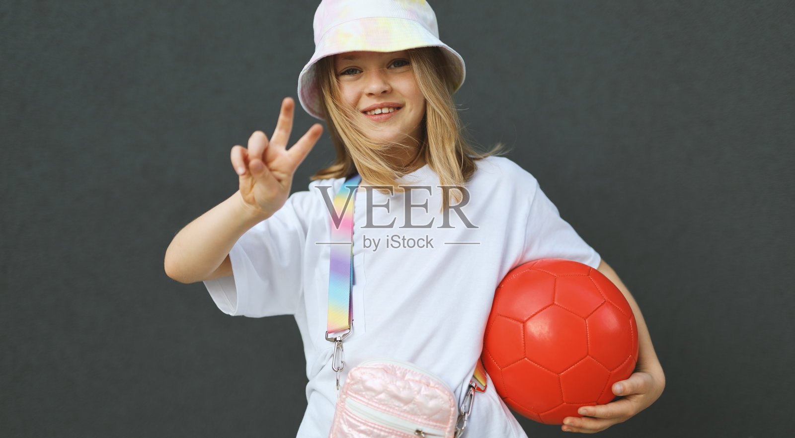 一个快乐的小孩在夏日的阳光下玩球，享受户外的乐趣。照片摄影图片