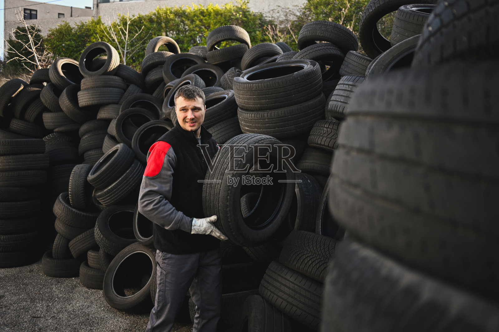 在垃圾场工作的帅哥。照片摄影图片