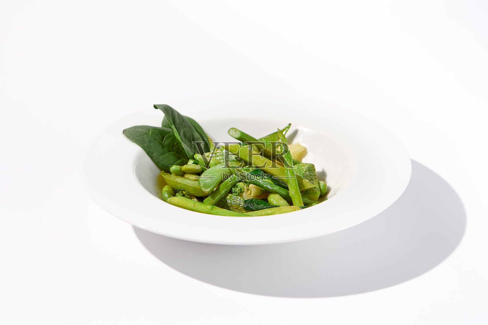 新鲜的绿色蔬菜配菜，以芦笋、西葫芦和毛豆为特色，在孤立的白色背景上照片摄影图片