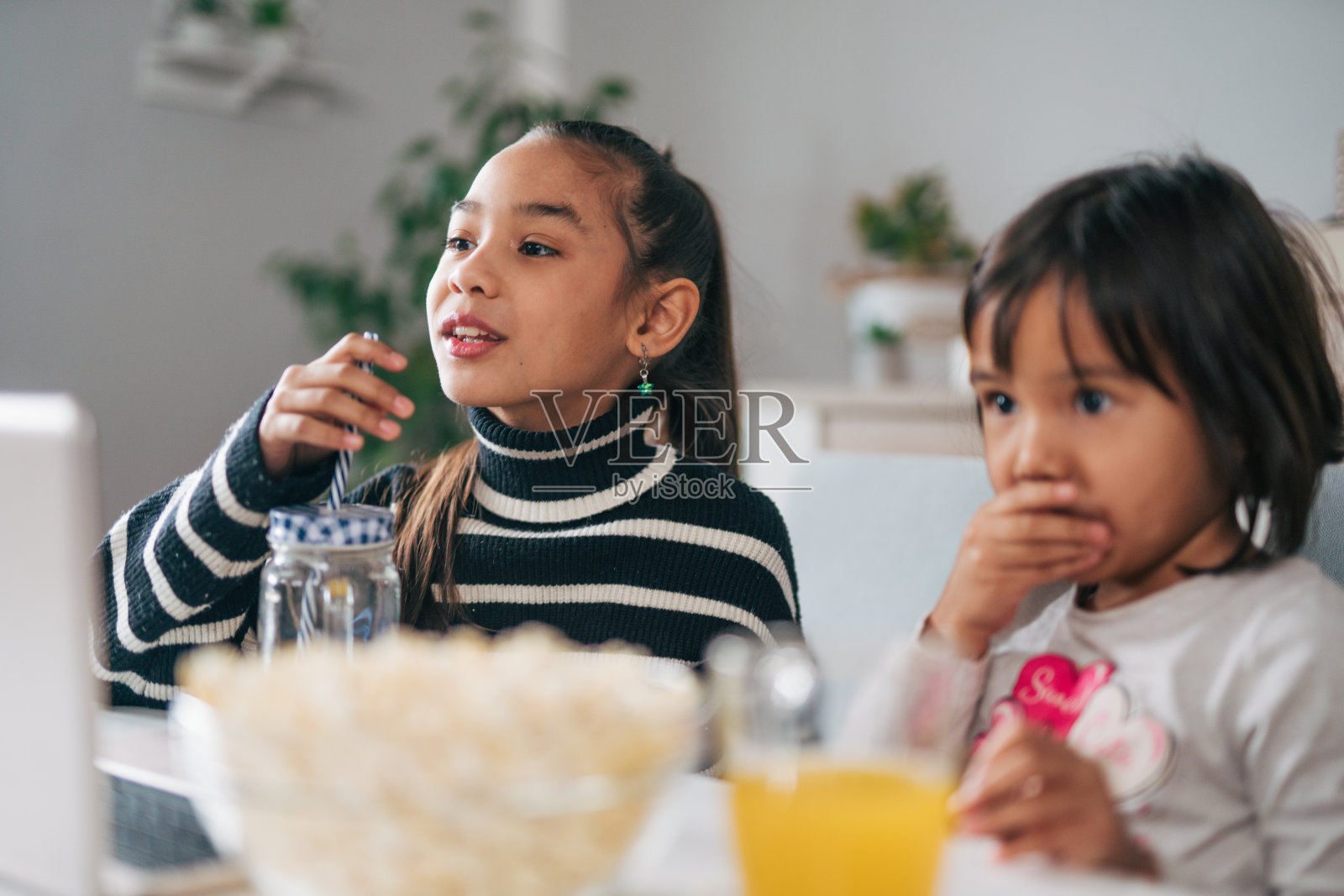 两个快乐的小女孩吃着爆米花照片摄影图片