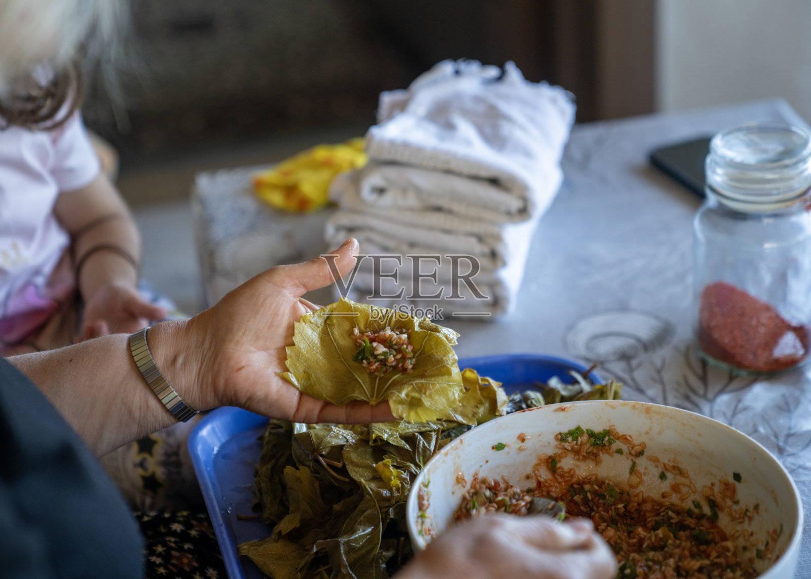 年长妇女与孙女聊天时卷萨尔玛的双手特写照片照片摄影图片