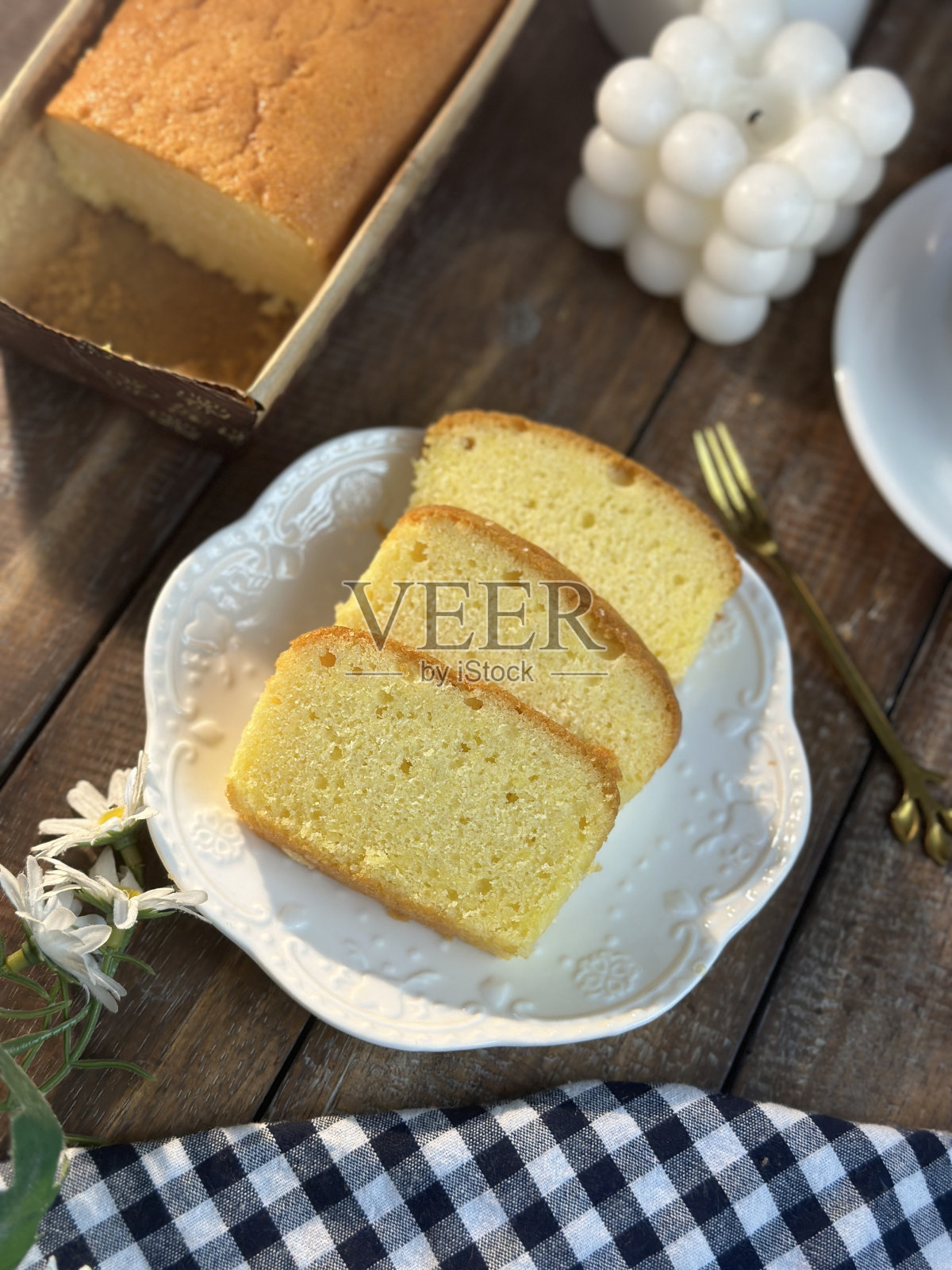 奶油蛋糕片配白色小茶具。照片摄影图片