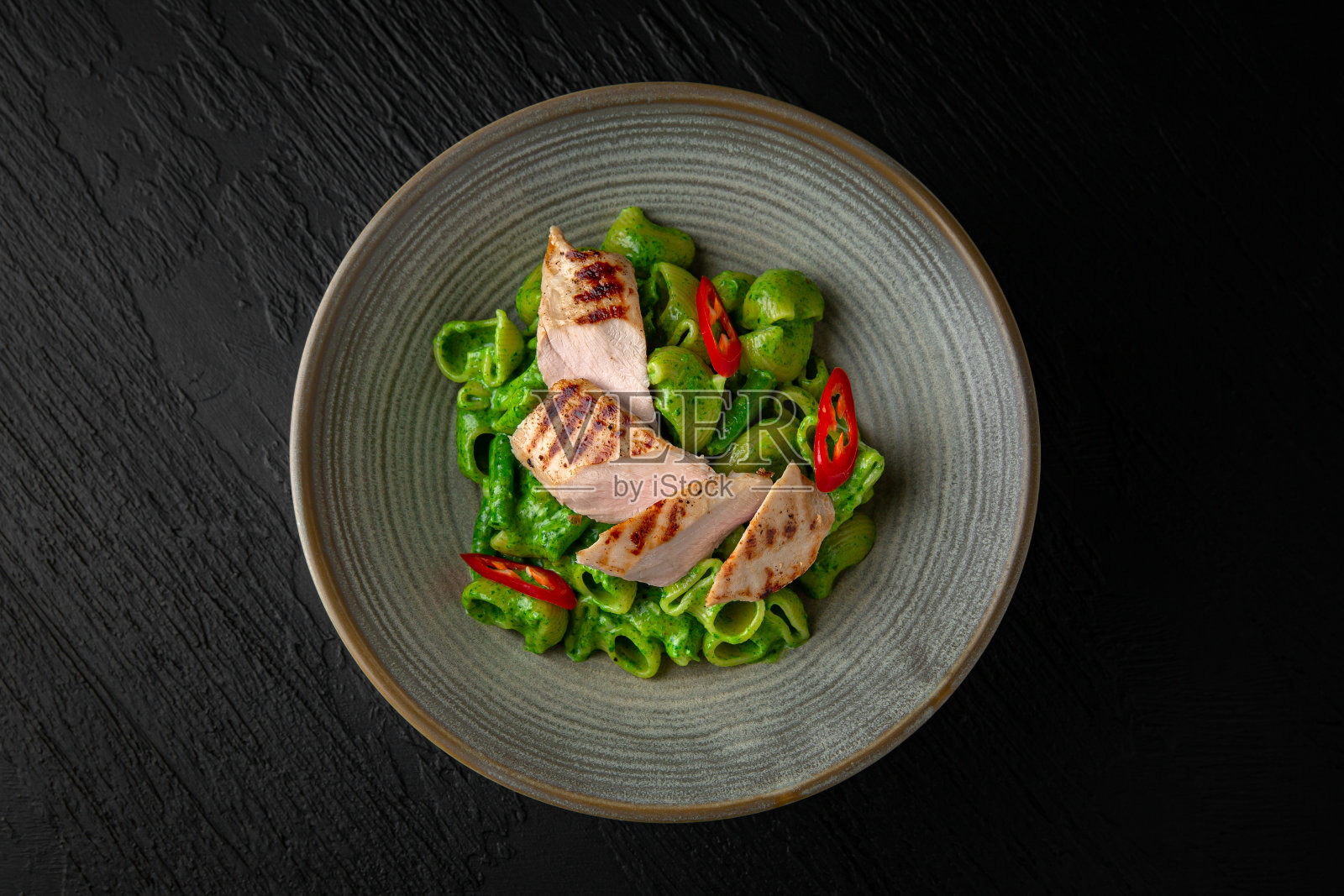 奶油意大利面，菠菜和火鸡在一个陶瓷盘子在深色纹理的背景。餐厅的菜单照片摄影图片