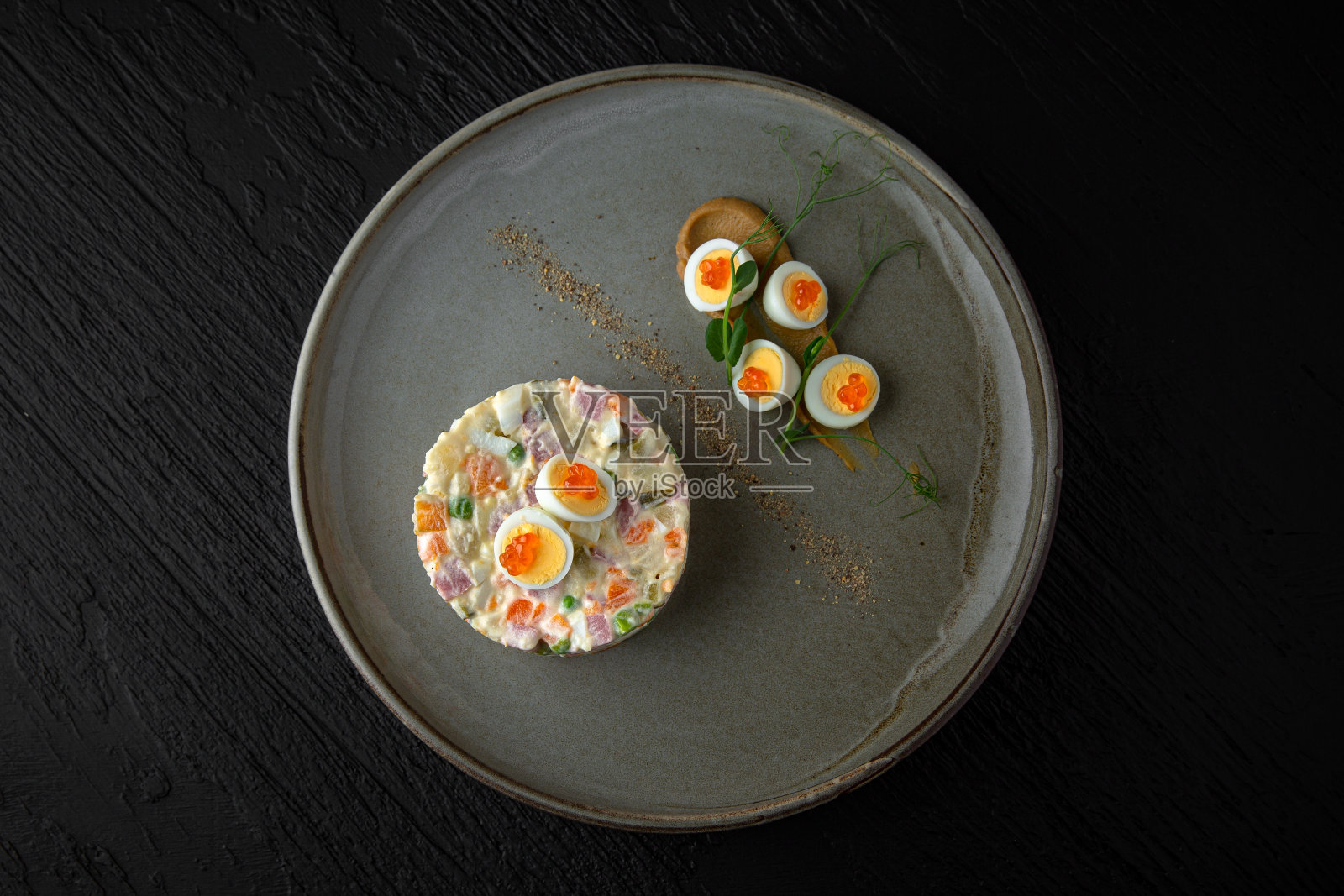 奥利维尔在一个陶瓷盘子在一个黑暗的纹理背景。餐厅的菜单照片摄影图片