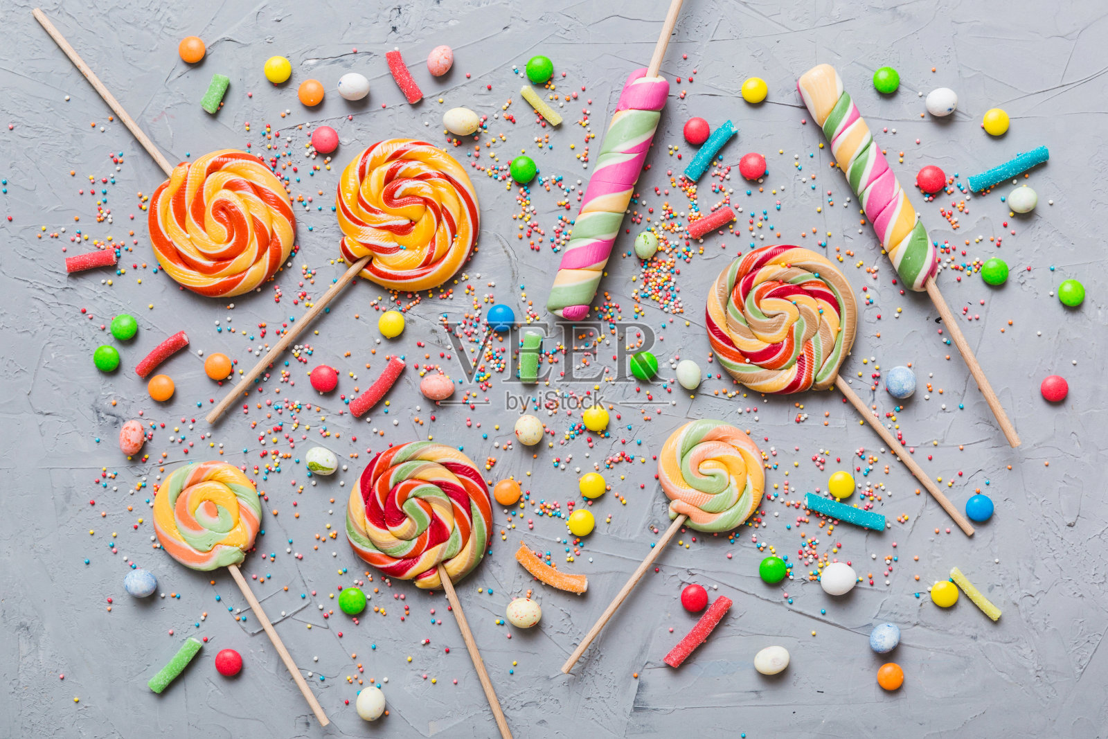 美味开胃的派对配件生日快乐甜蜜。不同类型的糖果在彩色背景上，复制空间。色彩缤纷的生日派对背景照片摄影图片