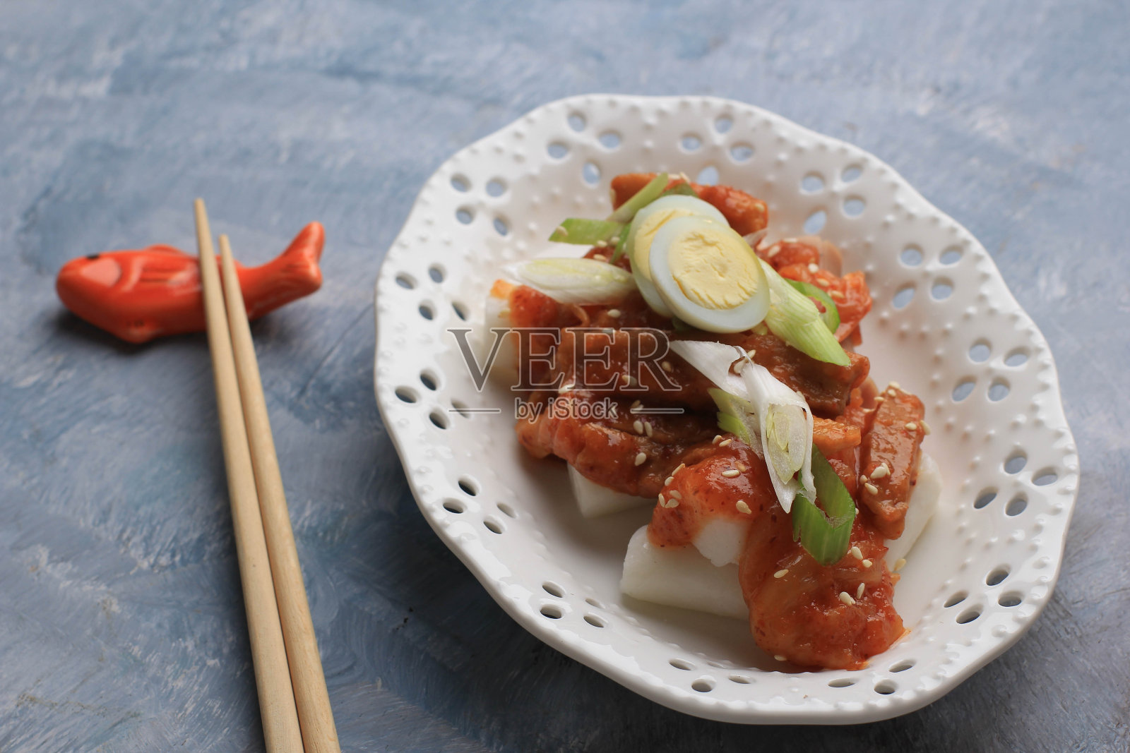 Topokki or Tteokbokki is Stir-fried Rice Cake with Vegetables and Fish Cake in Spicy Sauce Top with Sesame Seed, Famous and Popular Korean Street Food照片摄影图片