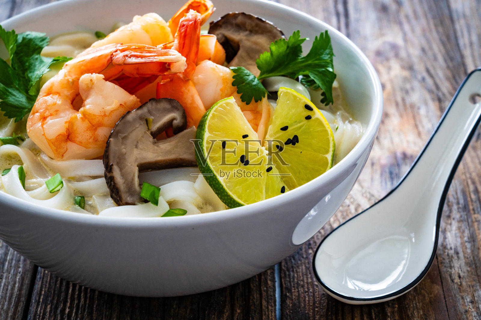 汤-椰子虾汤，面条和香菇在木桌上照片摄影图片