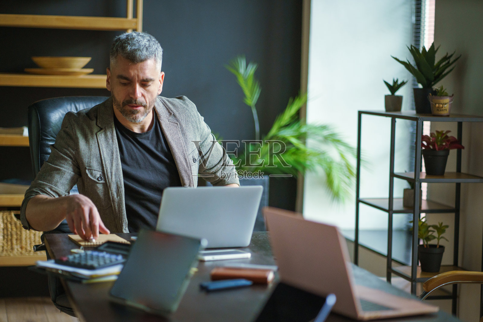 在办公桌前用笔记本电脑工作的人照片摄影图片