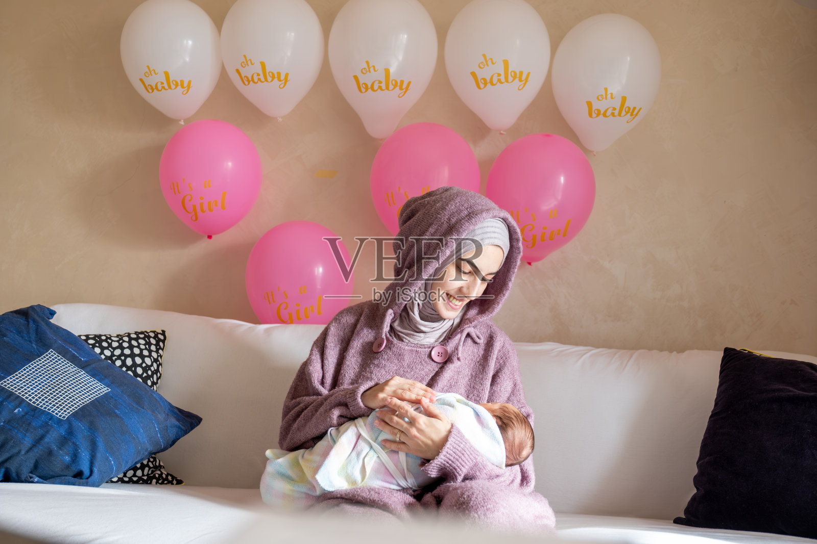 母亲手捧新生儿，感受着第一个月的爱与平安照片摄影图片