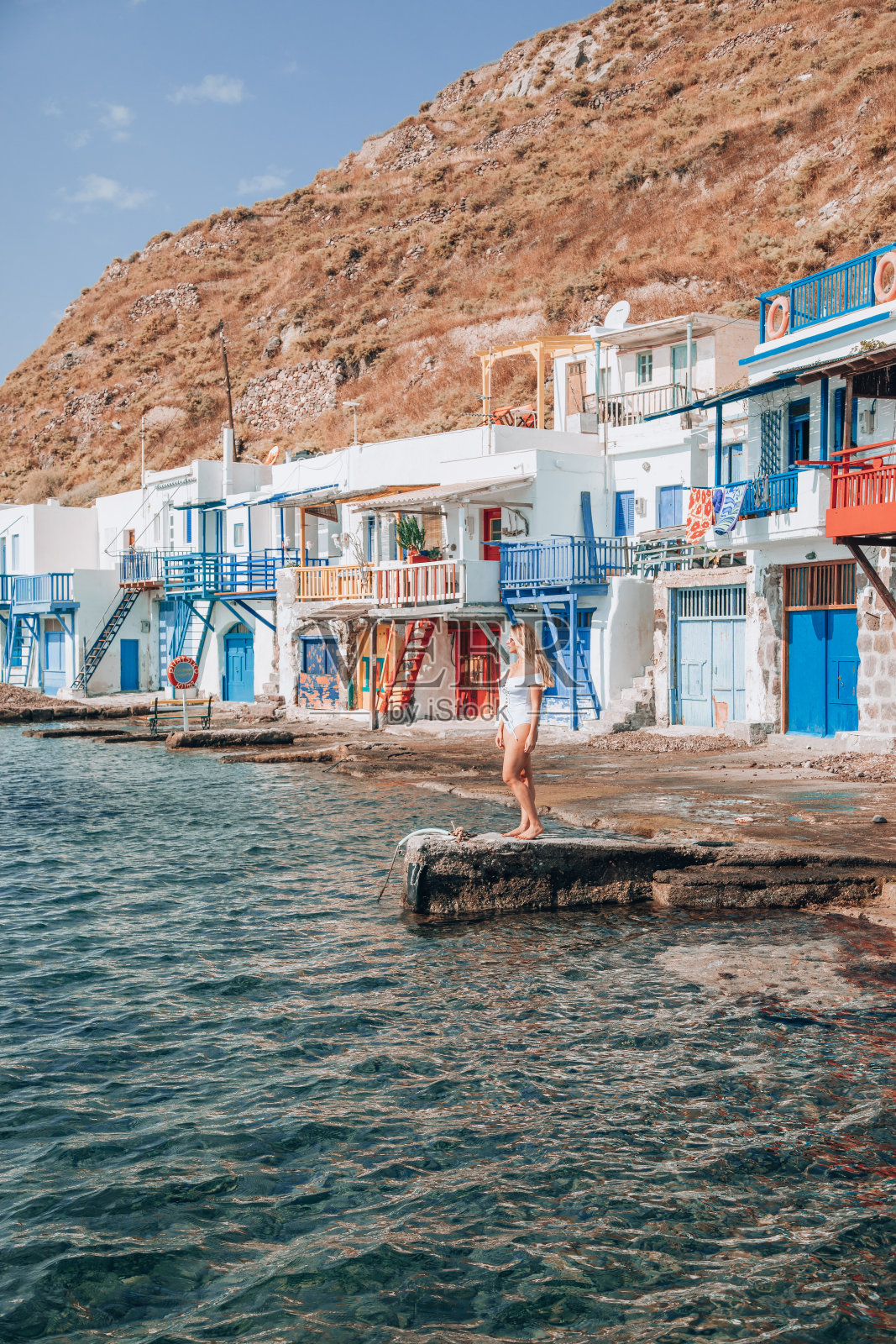 一名年轻女子喜欢旅行，欣赏希腊米洛斯岛上传统渔村Klima的景色照片摄影图片