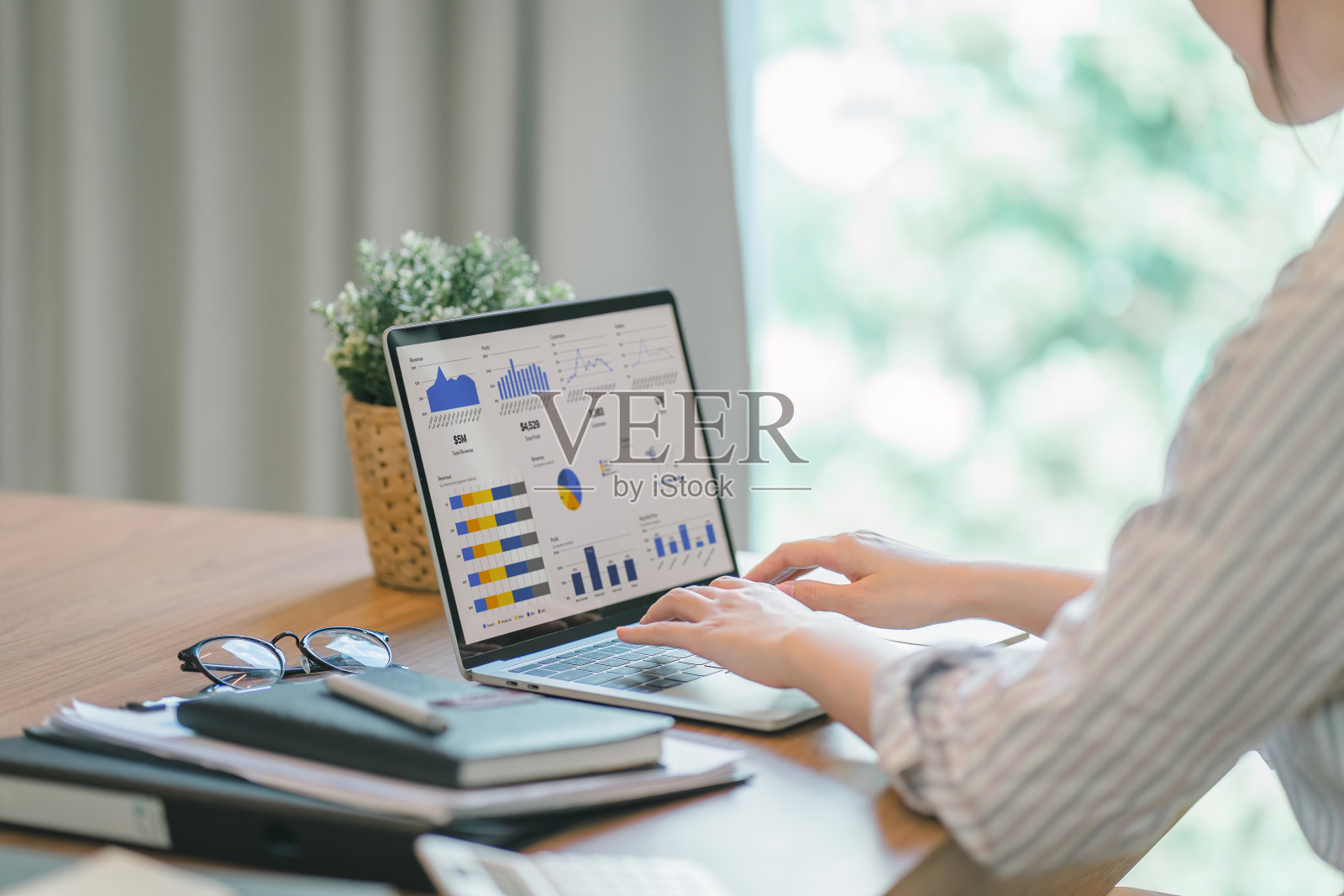 商业女会计，运用计算器、图表和图表分析市场数据、资产负债表、账目和净利润，以便制定新的销售策略和提高生产能力。照片摄影图片