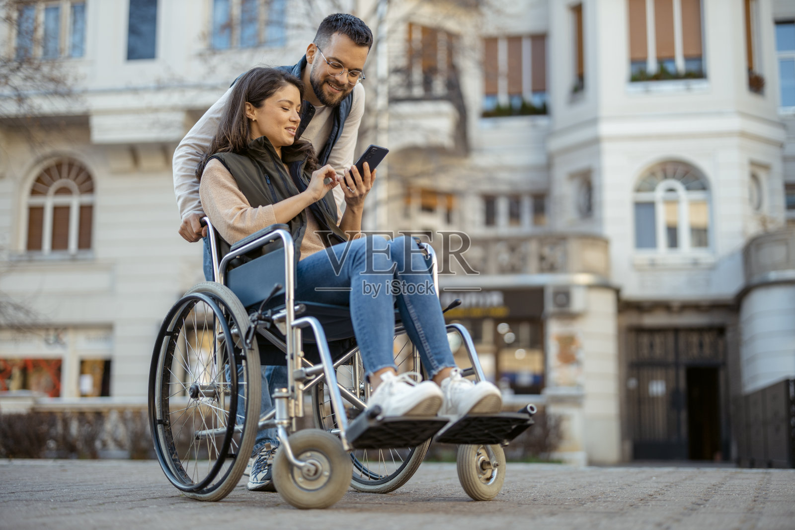 坐在轮椅上的夫妇在市中心使用智能手机照片摄影图片