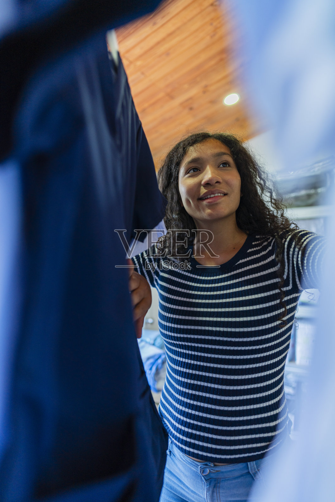 留着非洲式发型的拉丁女人，稍微整理一下她放衣服的地方照片摄影图片