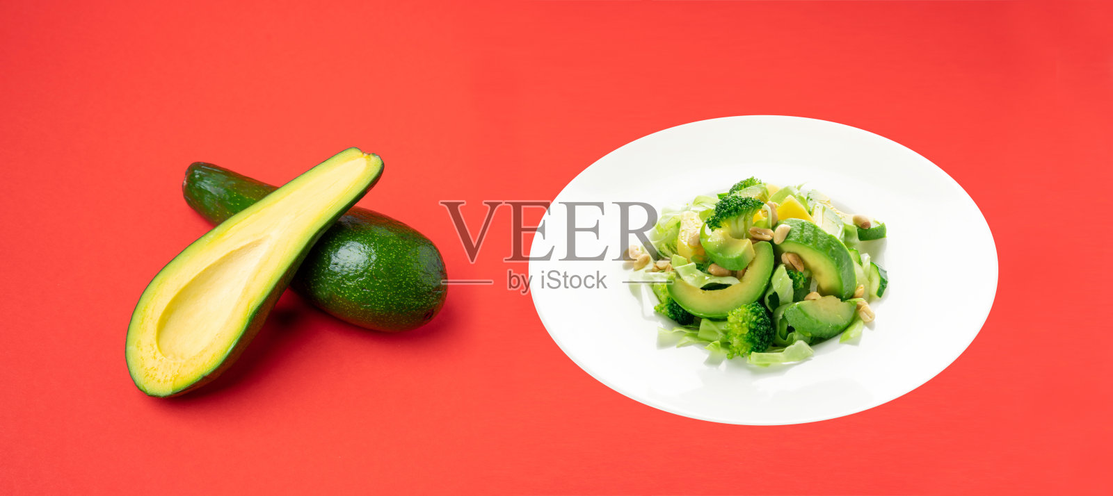 白盘子里的牛油果、黄瓜和坚果沙拉照片摄影图片