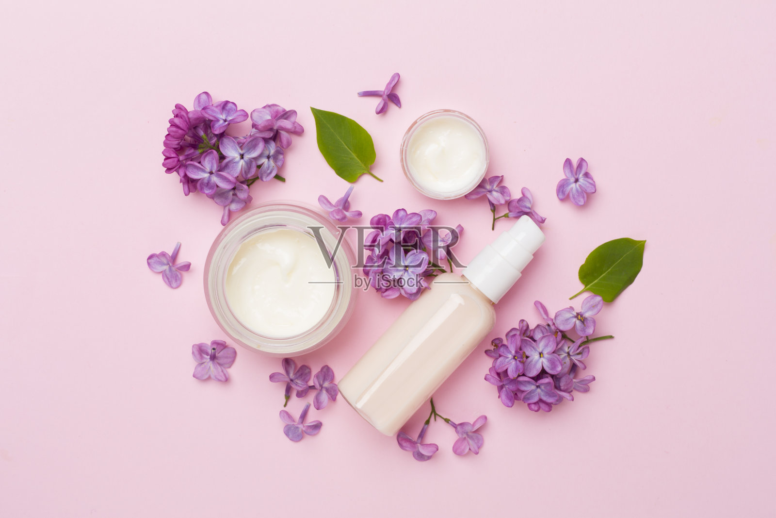 化妆品瓶子和花在彩色背景上的构图，俯视图照片摄影图片