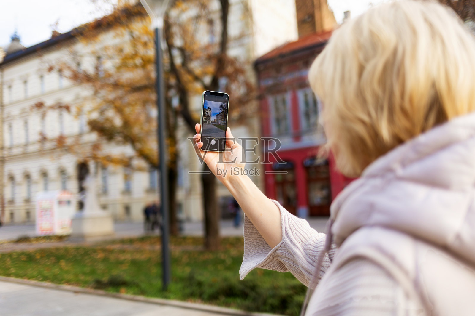 女子在旅行时用智能手机拍照。手的特写。后视图。社交媒体和在线交流的概念照片摄影图片