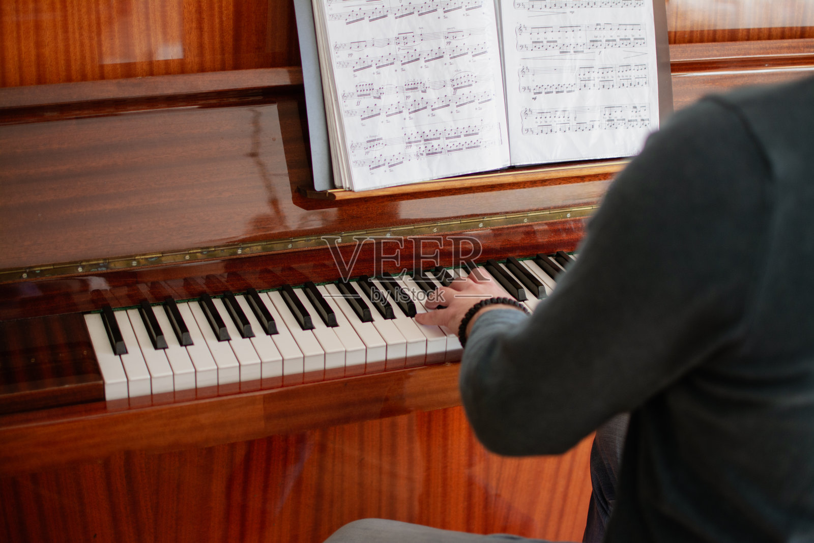 一个年轻人在弹钢琴照片摄影图片