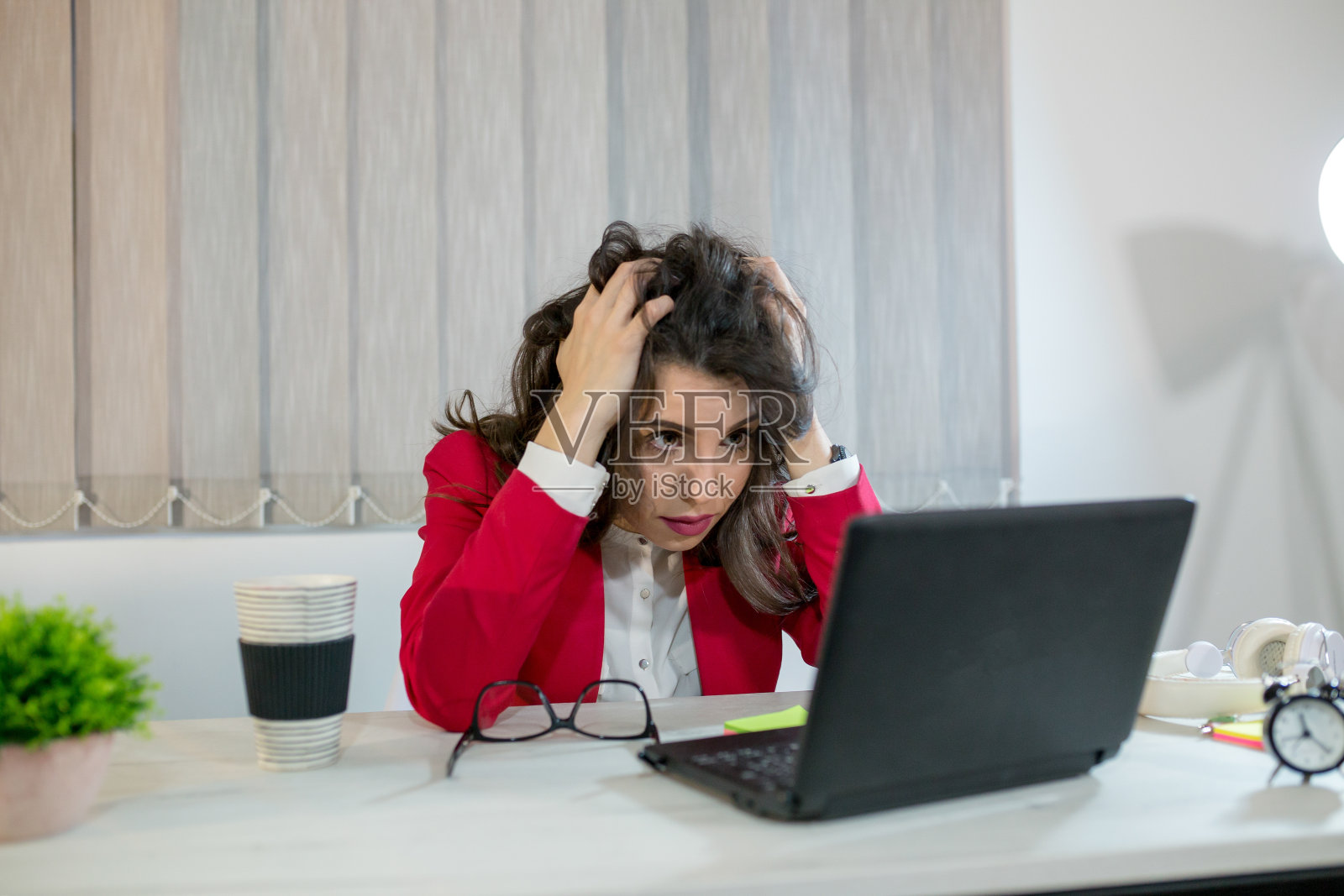 疲惫不堪、压力重重的女商人坐在家里的桌子前，一边用笔记本电脑工作，一边把手放在太阳穴上，偏头痛发作。自由职业者，在家工作。照片摄影图片