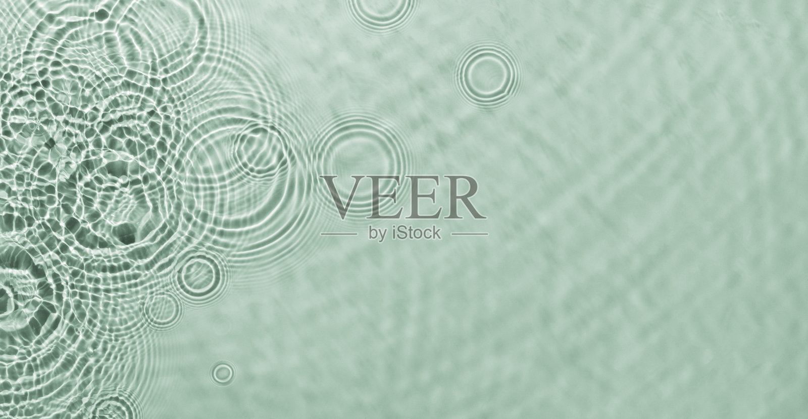 水在绿色的背景上荡漾。抽象水波纹纹理。照片摄影图片