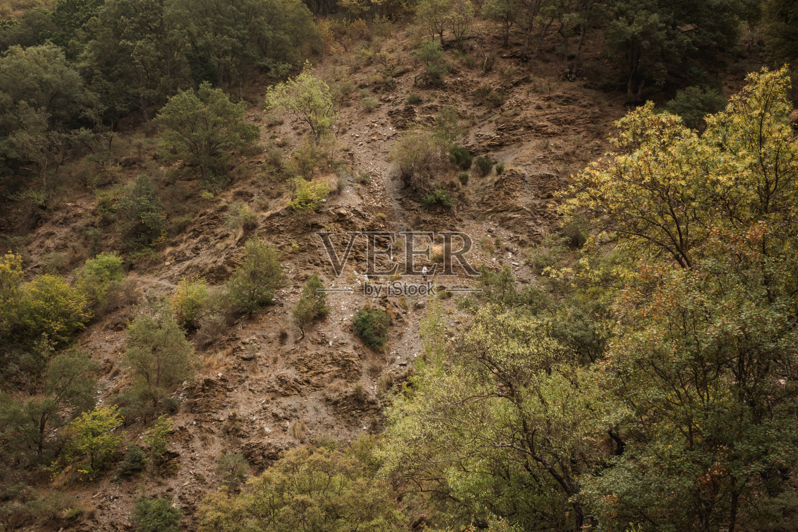 一个人在多云的秋日走在山间的小路上照片摄影图片