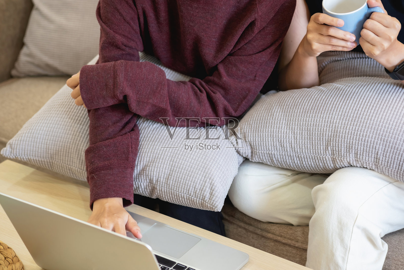 放松的年轻亚洲妇女享受放松在一个舒适的沙发在家里。美丽的女孩平静地放松，在屋里呼吸新鲜空气。看电影和社交网络。照片摄影图片