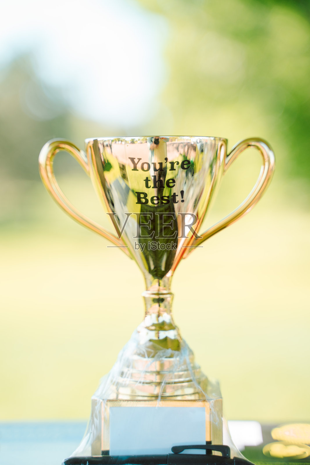 金色奖杯绿天光背景照片摄影图片