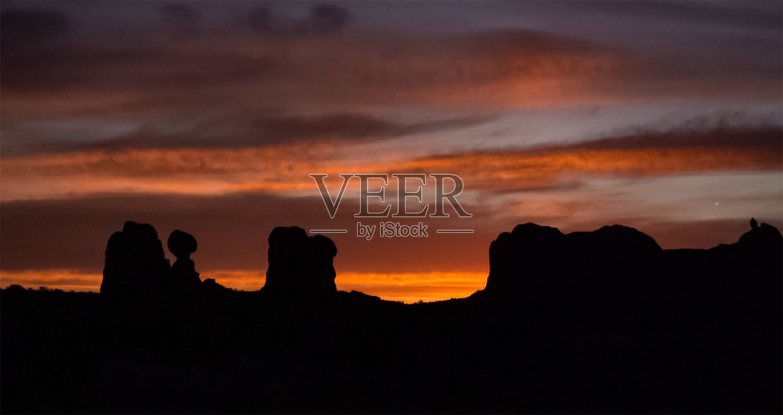 晚霞映衬着山景，山色红彤彤。峡谷地，摩押，犹他州照片摄影图片